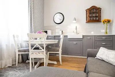 a kitchen with a table and chairs and a sink at HOUSEHOST Apartment :Zacisze Street in Kraków