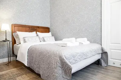 a bedroom with a large bed with white sheets at HOUSEHOST Apartment :Zacisze Street in Kraków
