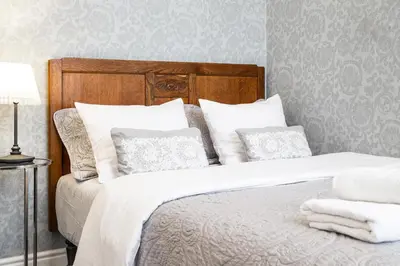 a bedroom with a bed with white sheets and pillows at HOUSEHOST Apartment :Zacisze Street in Kraków
