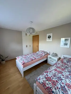 a bedroom with two beds and a chandelier at Villa Barwald in Barwałd Górny