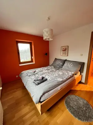 a bedroom with a large bed with orange walls at Villa Barwald in Barwałd Górny
