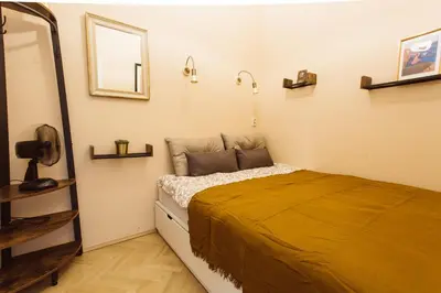 a bedroom with a bed with a yellow blanket at Krakowska 5 in Kraków