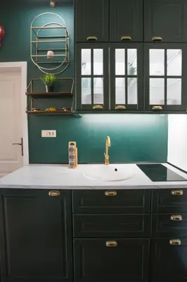 a kitchen with green cabinets and a sink at Krakowska 5 in Kraków