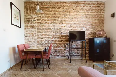 a dining room with a brick wall and a table and chairs at Krakowska 5 in Kraków