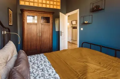 a bedroom with a bed and blue walls and a door at Krakowska 5 in Kraków