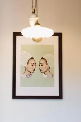 a picture of two women on a wall with a light at Krakowska 5 in Kraków