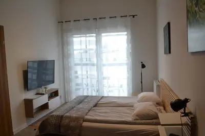 a bedroom with a large bed and a window at Apartamenty na Ceglanej in Oświęcim