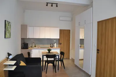 a living room and kitchen with a table and chairs at Apartamenty na Ceglanej in Oświęcim