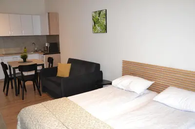 a kitchen and living room with a table and chairs at Apartamenty na Ceglanej in Oświęcim