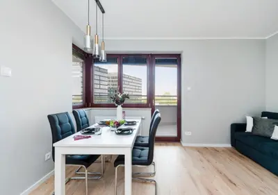 a dining room with a white table and chairs at P&P Apartments in Kraków