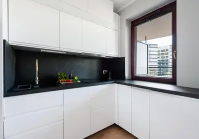a kitchen with white cabinets and a window at P&P Apartments in Kraków