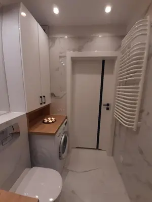 a bathroom with a toilet and a washing machine at P&P Apartments in Kraków