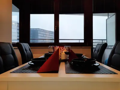 a table with glasses of wine and a table with chairs at P&P Apartments in Kraków