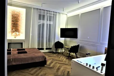 a bedroom with a bed and a tub and a television at Luxury Jacuzzi Apartment in Kraków