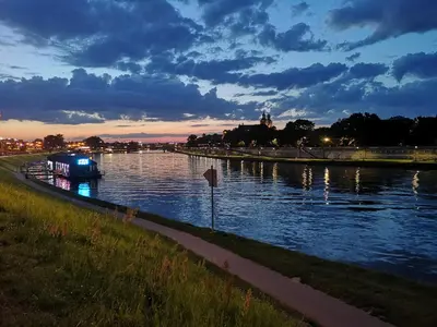 a boat on a river at night at Luxury Jacuzzi Apartment in Kraków