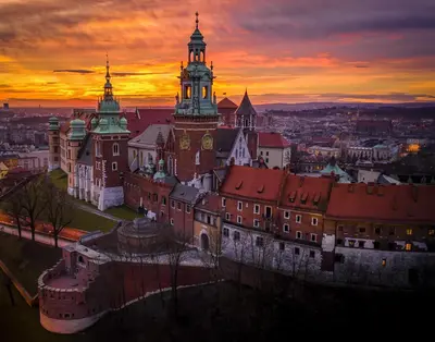 an old building with a clock tower at sunset at Luxury Jacuzzi Apartment in Kraków