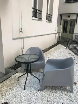 a table and a chair sitting next to a building at Historic Old Town Kazimierz 2 Garden View in Kraków