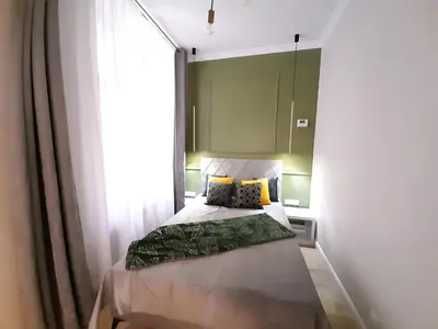 a small bedroom with a bed and a window at Cracowapart Hugo in Kraków
