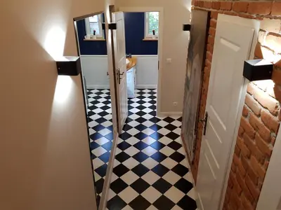 a hallway with a black and white checkered floor at Cracowapart Hugo in Kraków