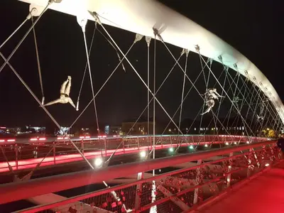a bridge with birds flying over a highway at night at Cracowapart Hugo in Kraków