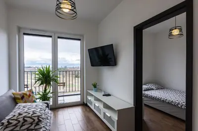 a living room with a mirror and a balcony at ENERGYLANDIA Zator Apartament Madzia in Zator