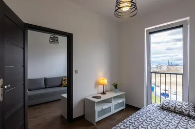 a bedroom with a bed and a window with a couch at ENERGYLANDIA Zator Apartament Madzia in Zator