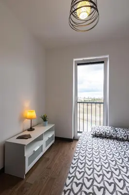 a bedroom with a bed and a large window at ENERGYLANDIA Zator Apartament Madzia in Zator