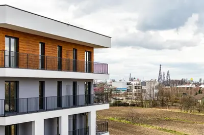 a building with balconies and a city in the background at ENERGYLANDIA Zator Apartament Madzia in Zator