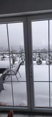 a sliding glass door with a view of a snow covered yard at Domki pod Groniem in Kasina Wielka