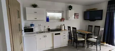 a kitchen and dining room with a table and a television at Domki pod Groniem in Kasina Wielka