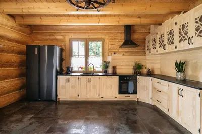 a kitchen with wooden walls and a refrigerator at NA BALI po góralsku in Poręba Wielka