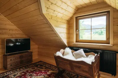 a room with a chair and a tv and a window at NA BALI po góralsku in Poręba Wielka