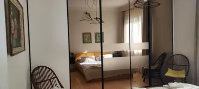 a bedroom with a mirror and a bed in a room at Hidden Gem Garden in Kraków