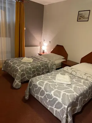 a hotel room with two beds with towels on them at Pensjonat Południe in Wieliczka