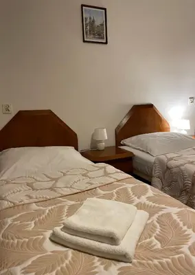 a bedroom with two beds with towels on them at Pensjonat Południe in Wieliczka