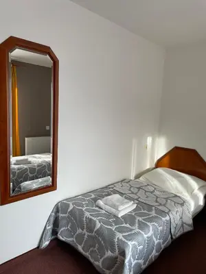 a bedroom with a bed and a mirror at Pensjonat Południe in Wieliczka