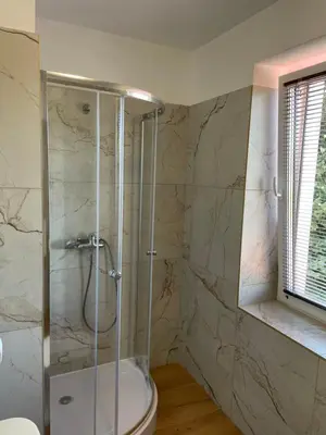 a bathroom with a toilet and a glass shower at Pensjonat Południe in Wieliczka