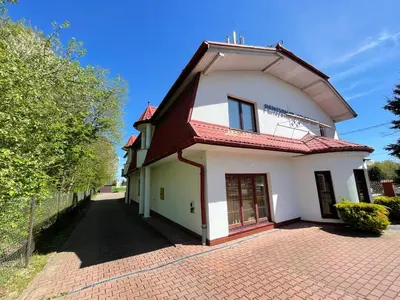 a white house with a red roof on a brick driveway at Pensjonat Południe in Wieliczka