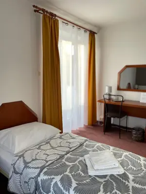 a hotel room with a bed and a desk and a computer at Pensjonat Południe in Wieliczka