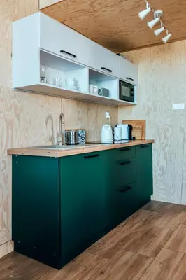 a kitchen with green cabinets and a counter top at Wierzbowa przystań in Czchów
