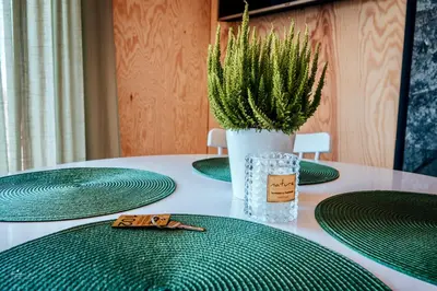 a table with green plates and a vase with a plant at Wierzbowa przystań in Czchów