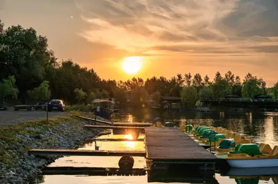 a dock with boats on the water at sunset at Wierzbowa przystań in Czchów