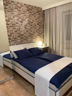 a bed in a bedroom with a brick wall at Apartament Podłęska in Kraków