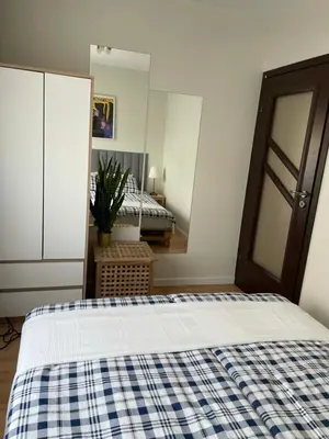 a bedroom with a bed with a blue and white checked blanket at Apartament Podłęska in Kraków