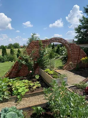 a garden with a brick wall and some plants at Siedlisko Przyjazne Progi in Rusocice
