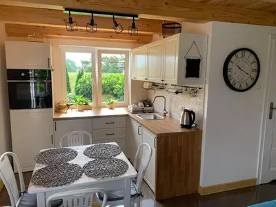 a kitchen with a table and a clock on the wall at Siedlisko Przyjazne Progi in Rusocice