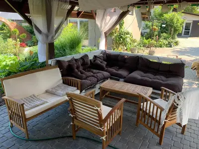 a patio with a couch and chairs and tables at Siedlisko Przyjazne Progi in Rusocice