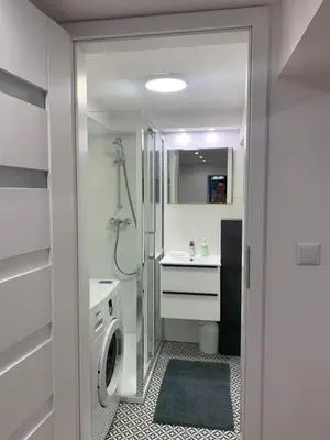 a bathroom with a washing machine and a sink at Rzeszowska Apt 01 in Kraków