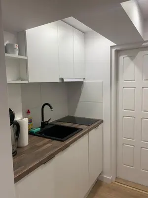 a kitchen with white cabinets and a sink at Rzeszowska Apt 01 in Kraków