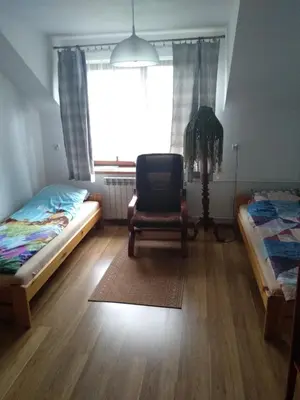 a bedroom with a bed and a chair and a window at Siedlisko Pauza in Kozłów